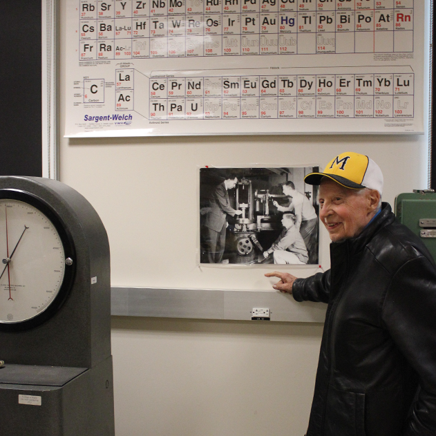 Dr. James Spilker Jr. pointing to a black and white photo
